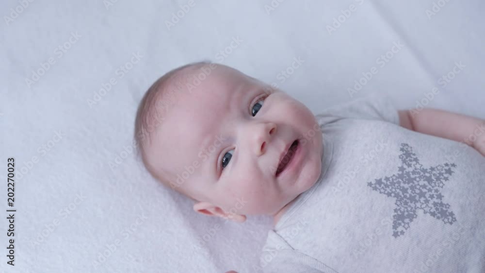 Baby's lying on a white linen in bed at home. Close-up shot Baby's lying on a white linen in bed at home. Close-up shot
