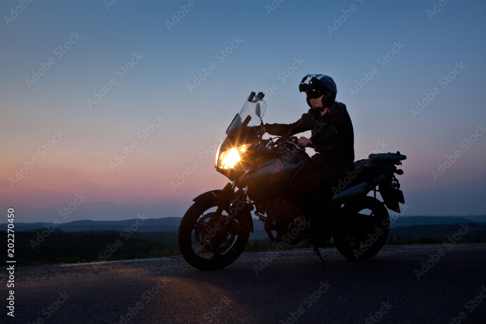man on his motorbike admiring sunset - summer road trip - space for text man on his motorbike admiring sunset - summer road trip - space for text