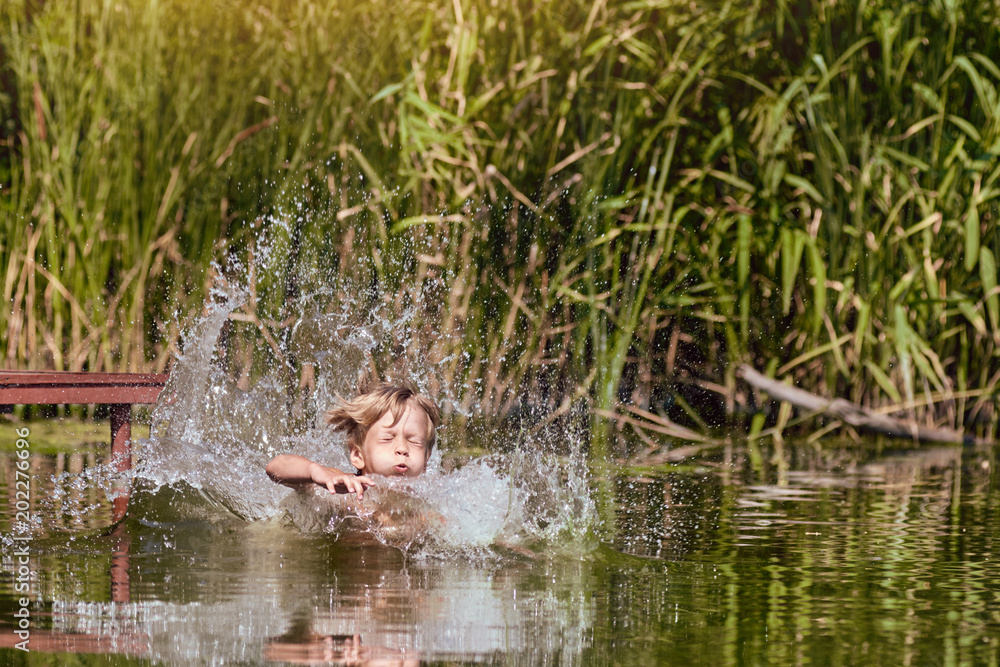 Young boy jumping, swimming and splashing in the river on summertime Young boy jumping, swimming and splashing in the river on summertime