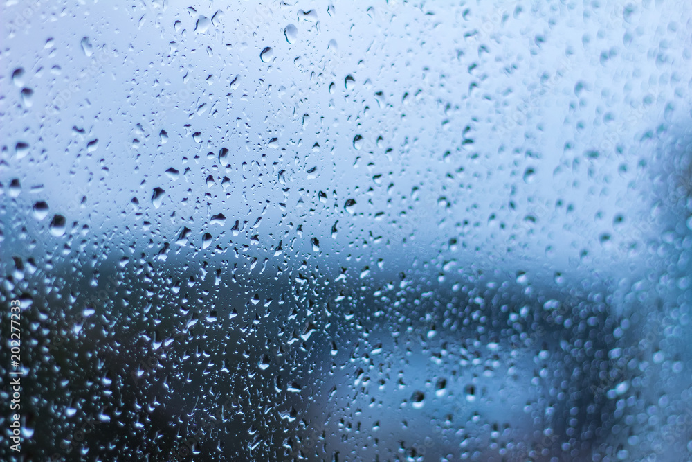 close up focused water drops on window glass in blue tone close up focused water drops on window glass in blue tone