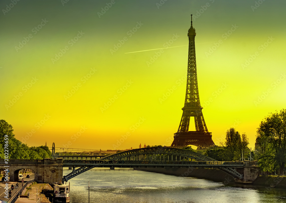 Fototapeta premium The Eiffel Tower and Cygnes bridge over river Seine at sunrise in Paris, France