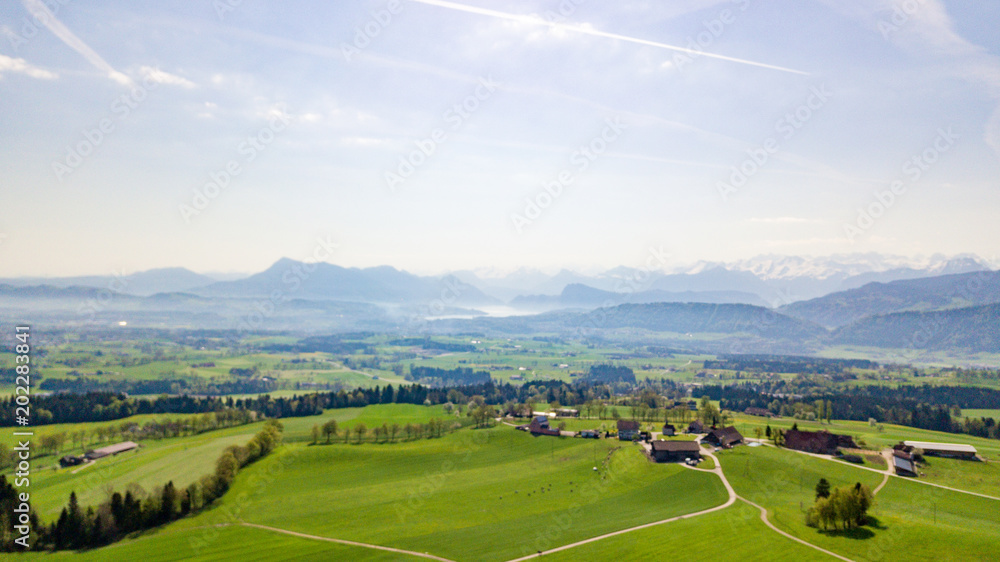 Panoramic view of idyllic mountain scenery in the Alps with fresh green meadows in bloom on a beautiful sunny day