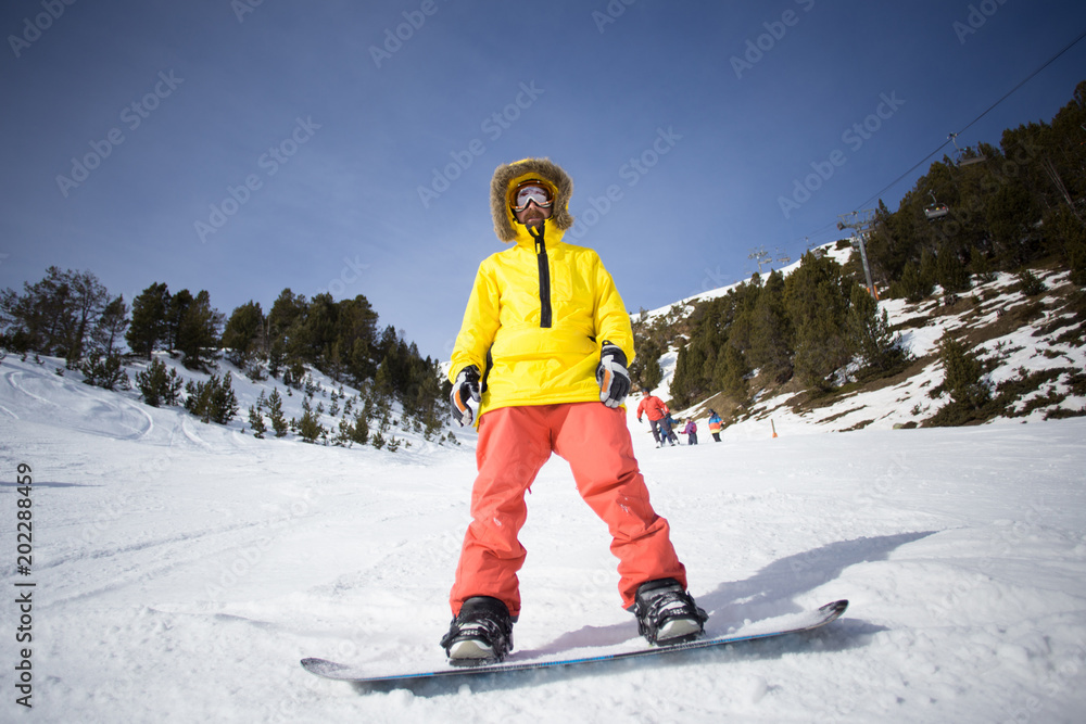 Cool and hipster snowboard rider looks down on slope, ready to do tricks  and flips, wears