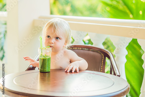 фотографія Child boy drinking healthy green vegetable smoothie - healthy eating, vegan, veg
