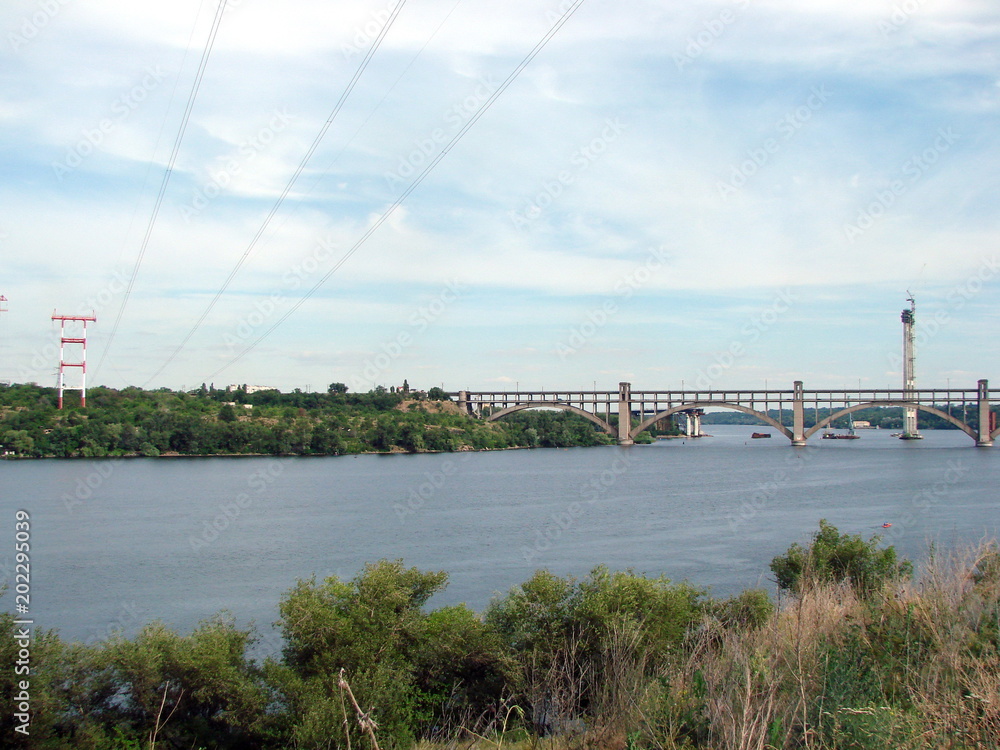 Fototapeta premium View of the bridge over the old channel of the Dnieper from the height of the hill of Khortytsia Island.