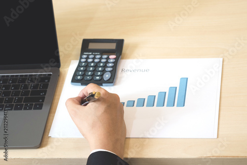 Success business man checking report profit on paper with rising charts, discussing company growth.