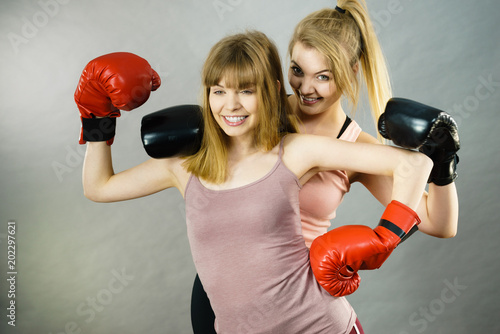 Two women friends wearing boxing gloves