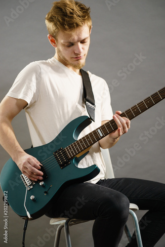 Young man playing electric guitar