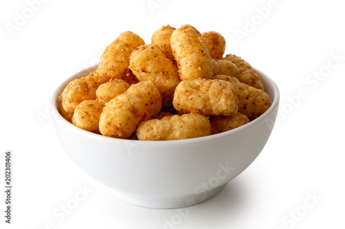 Extruded peanut flips in white ceramic dish isolated on white.