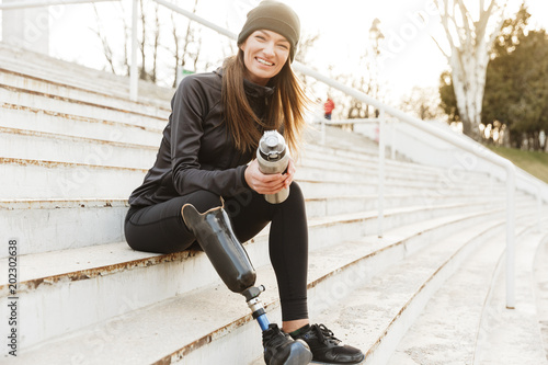 Canvastavla Strong willed handicapped woman in black tracksuit with prosthetic leg laughing,