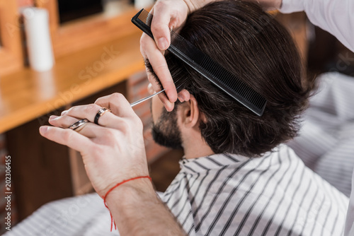 close-up shot of man getting haircut in barbershop