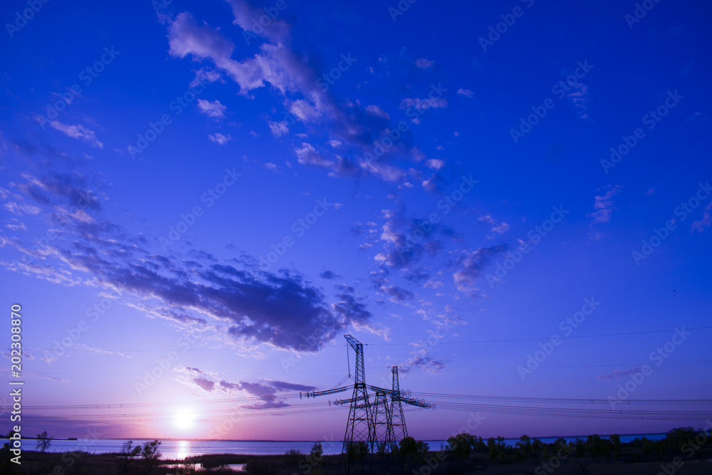 far power line against sunset background