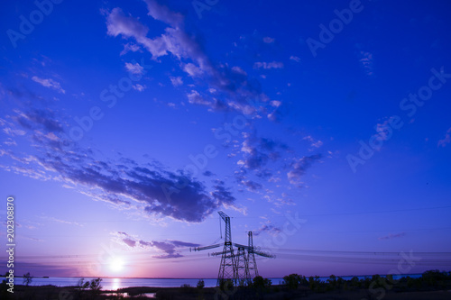 far power line against sunset background