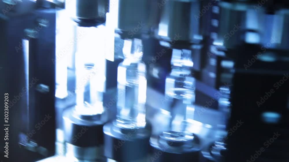 Pharmaceutical quality control of medical vials. Ultraviolet light in control technology of medical ampoules. Quality control of glass ampules at pharmaceutical plant. Pharmaceutical quality control of medical vials. Ultraviolet light in control technology of medical ampoules. Quality control of glass ampules at pharmaceutical plant.