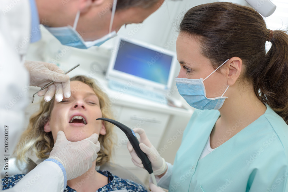 patient dentist and assistant in office of a dental clinic patient dentist and assistant in office of a dental clinic