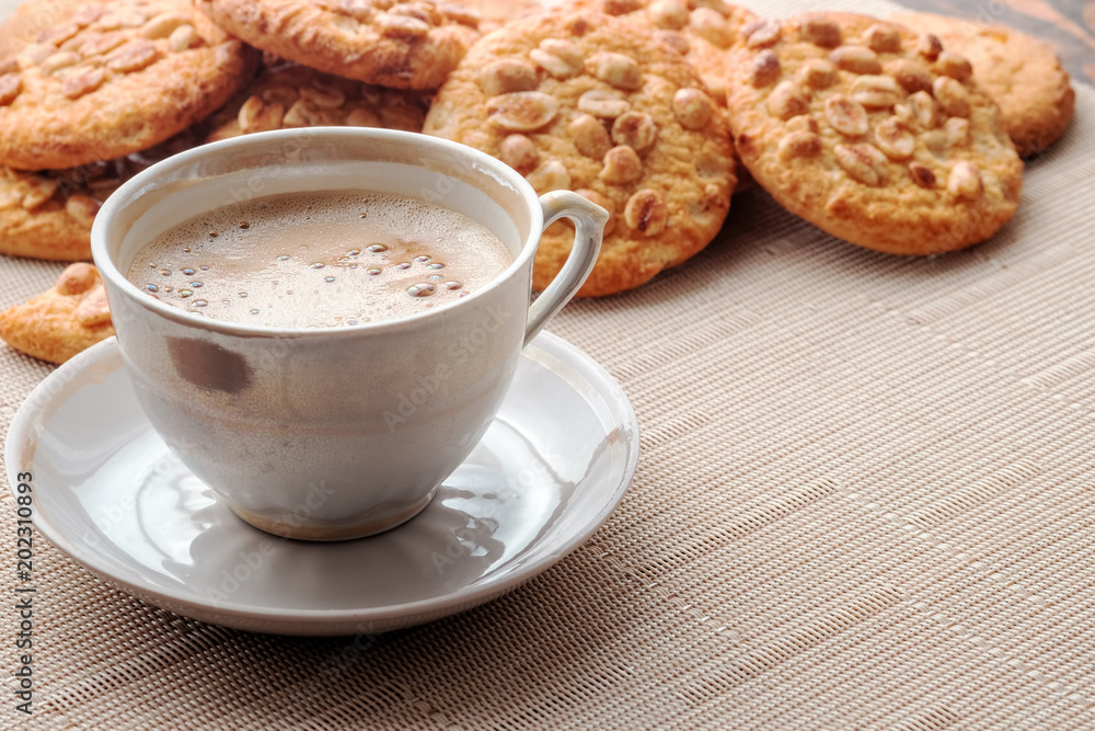 Cup of espresso and cookies with peanuts on light napkin. Copy space for your text. Close-up view. Cup of espresso and cookies with peanuts on light napkin. Copy space for your text. Close-up view.