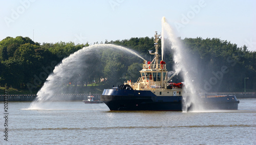 Fire fighting boat sprays water in port.