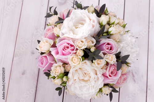 Bouquet for bride from different flowers on white wooden background.