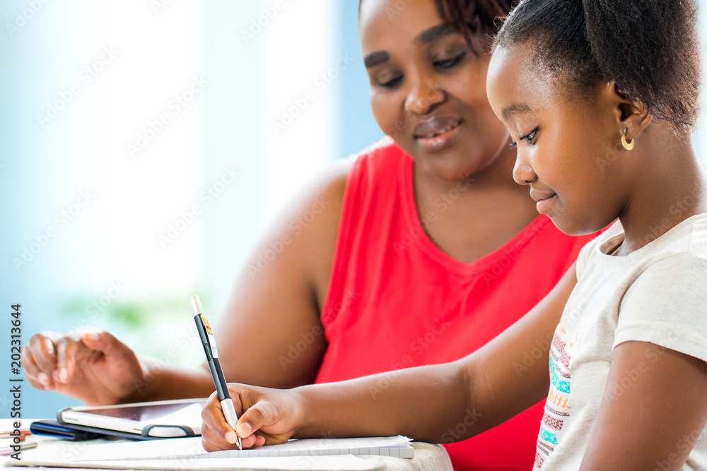 Little african girl doing home work with supervisor. Little african girl doing home work with supervisor.