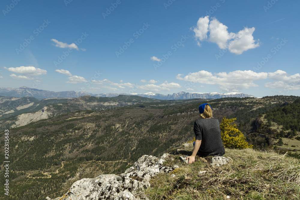 Woman enjoing a panoramic view on the snowy picked mountains in French Provence region.