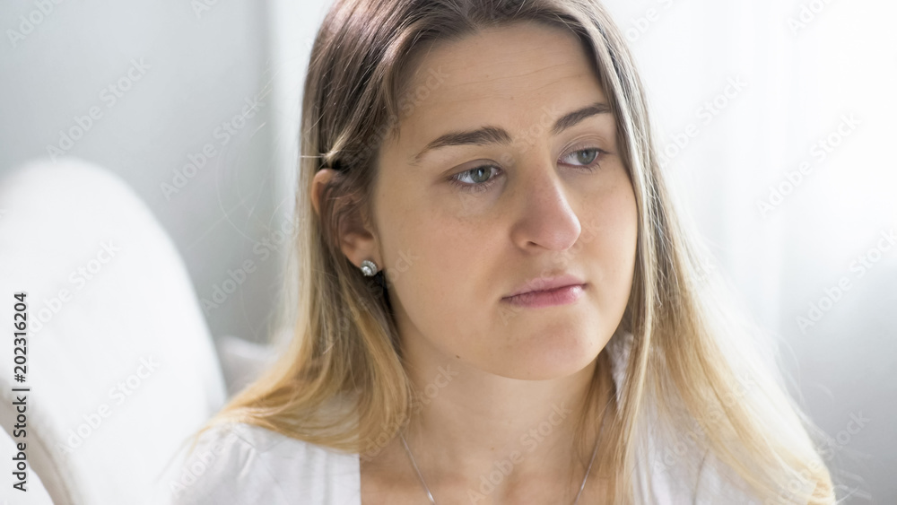 Portrait of young sick woman with cold sitting on sofa Portrait of young sick woman with cold sitting on sofa