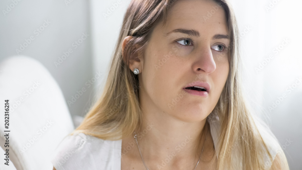Portrait of upset sick woman with flu sitting on sofa at home Portrait of upset sick woman with flu sitting on sofa at home