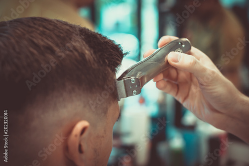 Man having a haircut with a hair clippers. Soft focus.