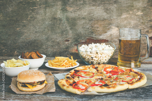     Fast food on old wooden background. Concept of junk eating. Toned image.  photo