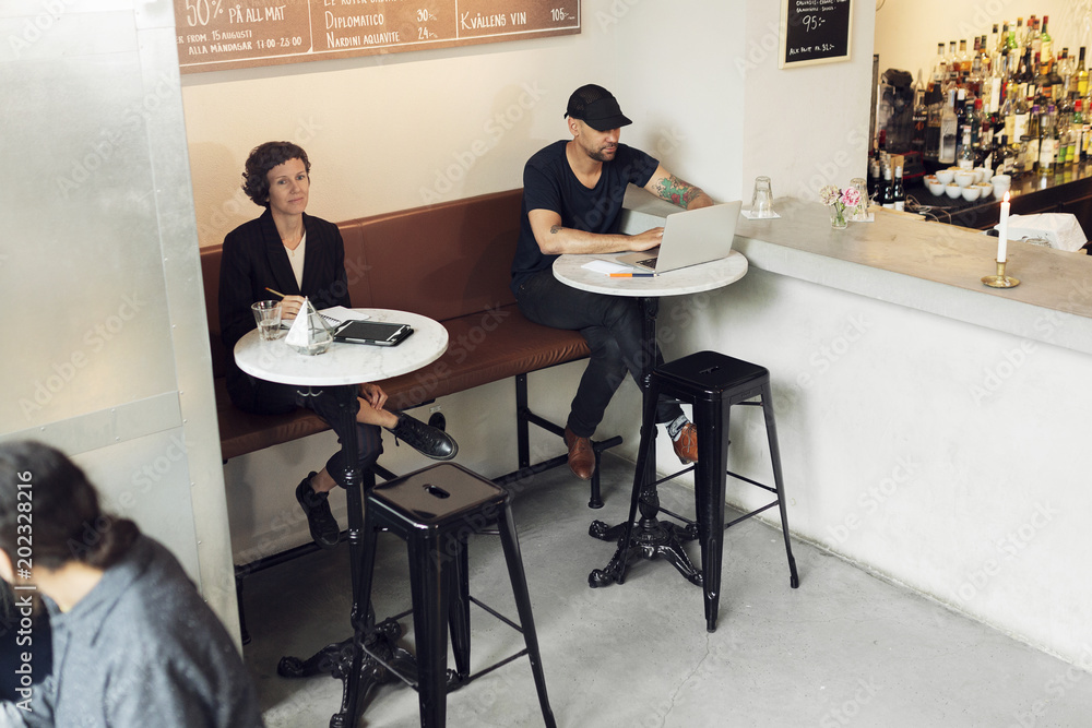 Man and woman with laptop in cafe Man and woman with laptop in cafe