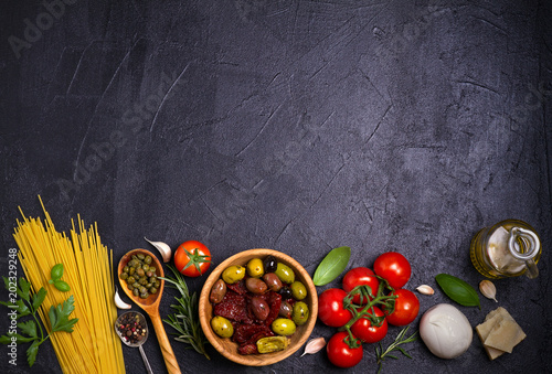 Selection of healthy food. Italian food background with spaghetti, mozzarella parmesan cheese, olives, tomatoes and rosemary. Vegetarian food banner. overhead, horizontal