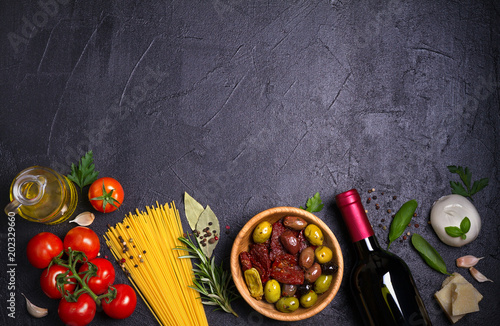 Selection of healthy food. Italian food background with spaghetti, wine, mozzarella parmesan cheese, olives, tomatoes and rosemary. Vegetarian food banner. overhead, horizontal