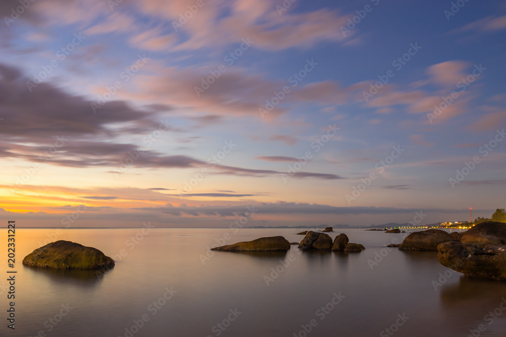 Colorful scenic sunset seascape with clouds on the sky and stones in water on Phu Quoc Island in Vietnam