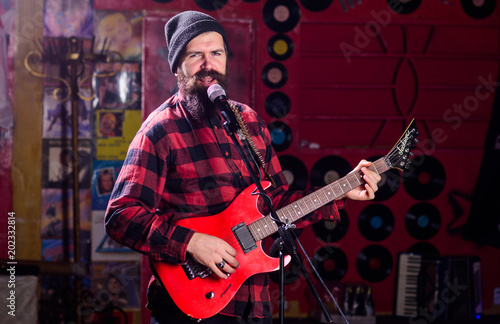 Musician with beard play electric guitar instrument. Frontman concept.
