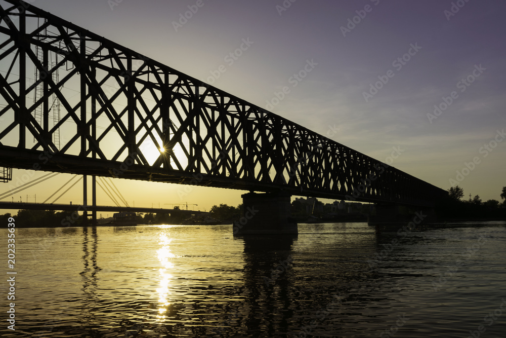 Under the bridge in sunset. Old railway bridge in Belgrade, Serbia. Bridge over the river in the city.