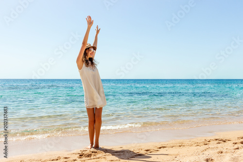 Woman relaxing at beach enjoying summer freedom. Happ girl at the beach