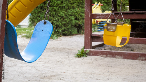 Closeup image of swings on empty children playground