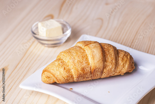 croissant on the table, next to butter and corn