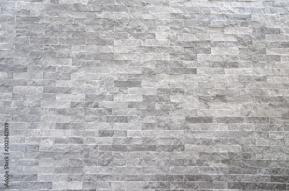 Obraz premium A gray stone wall surface with cement a background texture.