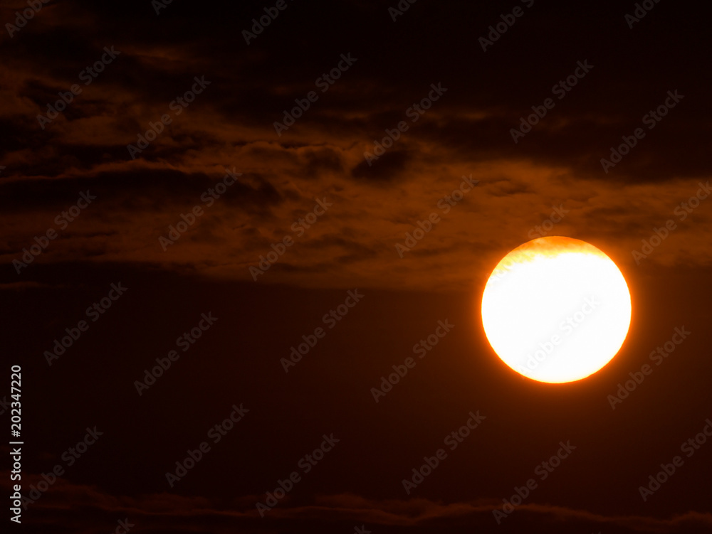 White Sun behind The Red Clouds and Sky White Sun behind The Red Clouds and Sky