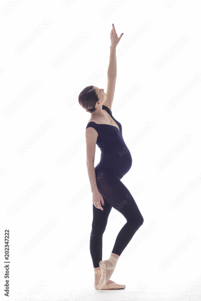 Young beautiful ballerina is posing in studio