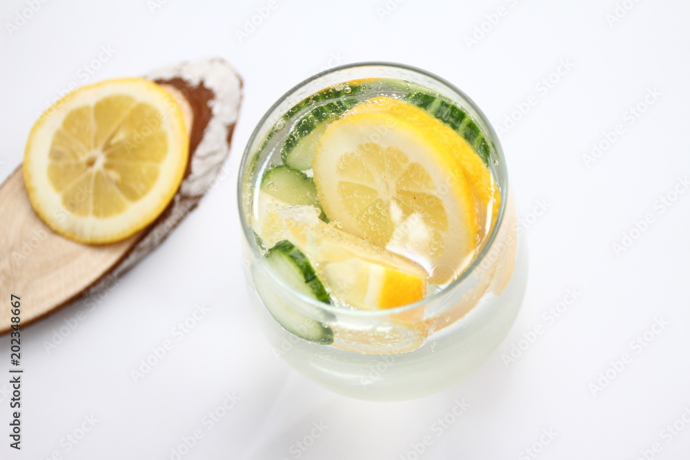 Detox flavored water with lemon and cucumber on white background with wood decoration. Healthy food concept.  Refreshing summer homemade cocktail. Copy space. No sharpen. 