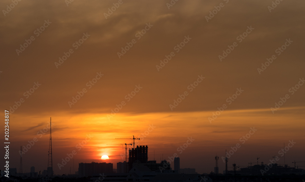 sunset time with golden hour sky and cityscape silhouette