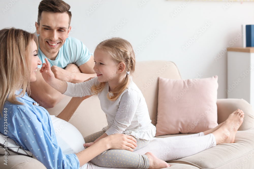 Fototapeta premium Young pregnant woman with her family at home