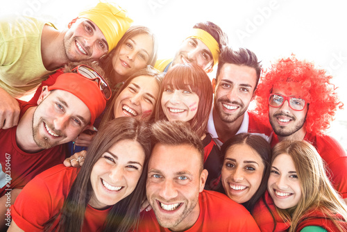 Happy sport friends taking selfie at world soccer event - Friendship concept with young people having fun at international stadium - Football cup championship concept on warm sunsine halo filter