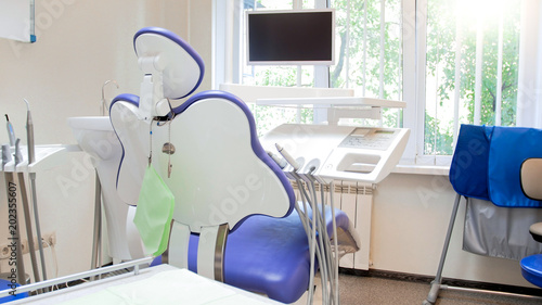 Closeup image of empty dentist chair and medical equipment in modern clinic