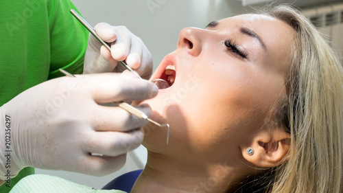 Closeup image of dentist holding mirror for teeth inspection