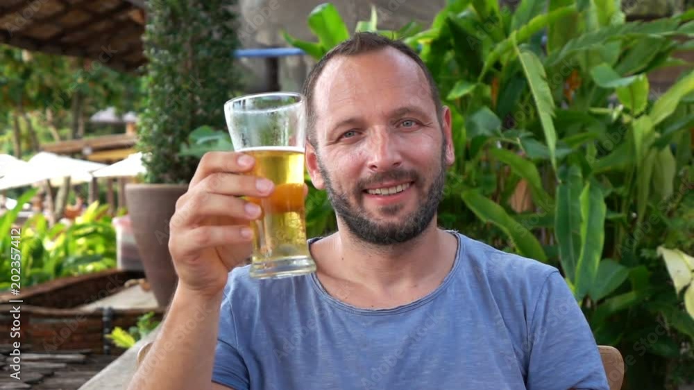 Young man raising toast with beer to camera, super slow motion, 240fps
Young man raising toast with beer to camera, super slow motion, 240fps