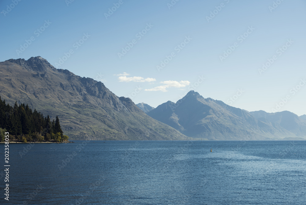 Paisaje de montañas frente a un lago. Escena diurna, cielo azul y despejado. Nueva Zelanda.