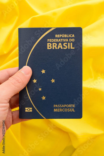 Brazilian passport on yellow fabric representing the Brazilian flag. Important   document for trips abroad.