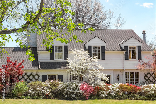 Traditional upscale home with dogwood tree and azelea bushes - beautifully landscaped in springtime